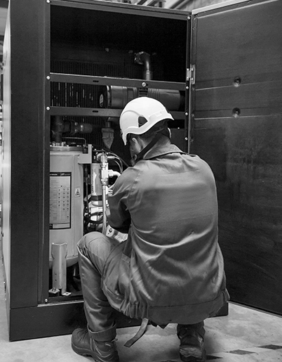 Technician performing maintenance on a breathing air unit